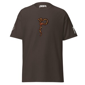 May include: A dark brown t-shirt with a snake design in brown, orange, and yellow. The word "SIENER" is printed in white at the top. White graphics are on the sleeves.