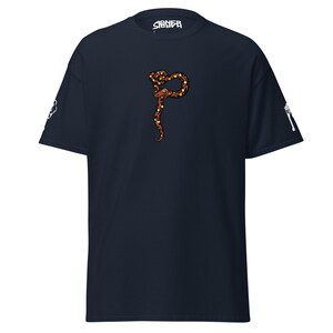 May include: Navy blue t-shirt with a brown and yellow snake design. The word "SIGNEA" is printed in white on the upper center of the shirt. White graphics are on the sleeves.