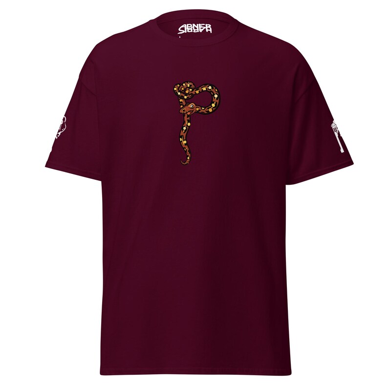 May include: Burgundy t-shirt with a detailed illustration of a snake in brown, gold, and black. The snake is in the centre of the shirt. The word "SIGNEЯ" is printed in white on the collar.
