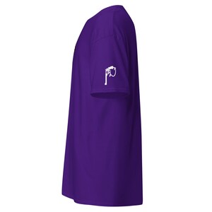May include: A plain purple t-shirt with a white graphic on the left sleeve. The graphic is a white illustration of a fuel pump. The shirt is made of a soft material.