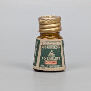 May include: A small amber glass bottle with a gold screw-top lid. The label is green and white with the text NEO-FEMERGIN, 10 TABLETS, POISON, and SANDOZ PRODUCTS LIMITED. It specifies For Obstetrics and Gynaecology and Mfd. in Switzerland.