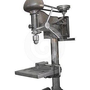 May include: A vintage metal drill press with a gray finish. The drill press has a table with a vise and a belt drive system.
