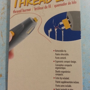 May include: A yellow and gray thread burner tool with a retractable tip. The tool is labeled "Ultra Thread Zap" and "thread burner/brûleur de fil/quemador de hilo".
