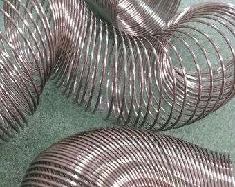 May include: A silver metal slinky toy, a classic spring toy that can be stretched and compressed.