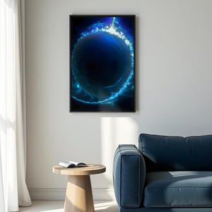 Puede incluir: Impresión artística enmarcada que presenta una esfera azul oscuro con patrones de energía azul brillante. La obra de arte está en un marco negro y cuelga de una pared blanca. Una pequeña mesa auxiliar de madera y un sofá azul están en primer plano.