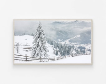 Könnte beinhalten: Eine verschneite Winterlandschaft mit einem hohen, schneebedeckten Nadelbaum im Vordergrund. Der Baum ist von einem Holzzaun und einem schneebedeckten Hügel umgeben. Im Hintergrund befinden sich schneebedeckte Berge mit Nebel.