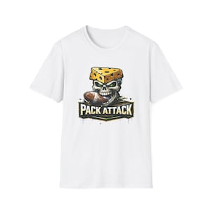 Puede incluir: Camiseta blanca con un gráfico de una calavera con un sombrero de cuña de queso y un balón de fútbol. El diseño incluye el texto "PACK ATTACK" en un estilo desgastado, con acentos verdes y dorados.