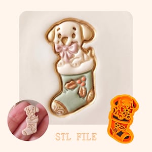 May include: A cookie cutter and a corresponding embossed cookie design featuring a puppy wearing a bow inside a Christmas stocking decorated with holly berries and leaves. The text STL FILE is printed below the embossed cookie design.