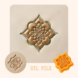 May include: A detailed, gold-colored floral design is embossed on a light beige surface. The image includes a round stamp and a square-shaped mold of the same design. The text "STL FILE" is printed in a light brown color.