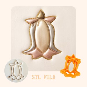 May include: A bell-shaped cookie cutter design featuring a central oval and flared edges. The image displays a metallic-painted embossed version in gold, silver, and rose gold, a white outline stamp, an orange plastic cutter, and the text STL FILE.