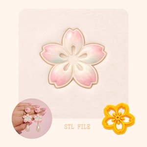 Puede incluir: Un cortador de galletas en forma de flor rosa y blanca, con un juego de pendientes a juego y una galleta terminada. La imagen también incluye el texto "STL FILE".