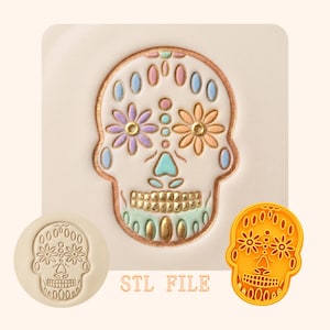 May include: A colorful sugar skull design with floral accents and the text "STL FILE". The skull features a white base with gold, blue, pink, and green details. A stamp and a 3D printed version are also shown.