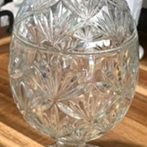 Dulcera vintage de cristal tallado con forma de huevo, con tapa y base hexagonal.