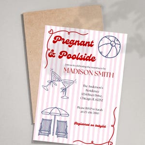 May include: A baby shower invitation with a pink and white striped background. The invitation features red text that reads "Pregnant & Poolside" and includes illustrations of a beach ball, martini glasses, and beach chairs. The invitation is on top of a brown envelope.