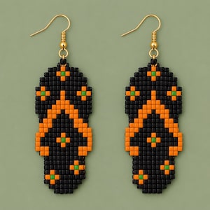 May include: A pair of beaded dangle earrings shaped like flip-flops. The earrings feature a black base with orange straps and small green square accents. Each earring hangs from a gold-toned metal hook, creating a vibrant and detailed design.