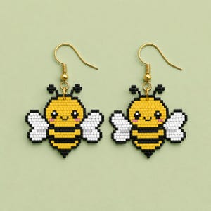 Pode incluir: Um par de brincos pendentes com um design de abelha em pixel art feito de pequenas contas quadradas. A abelha tem um corpo amarelo com listras pretas, asas brancas e um rosto sorridente com bochechas rosadas em ganchos de metal dourado.