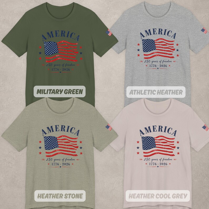 May include: Four short-sleeve crew neck t-shirts in military green, athletic heather, heather stone, and heather cool grey. Each shirt features a graphic of the American flag with the text AMERICA, 250 years of freedom, and 1776-2026.