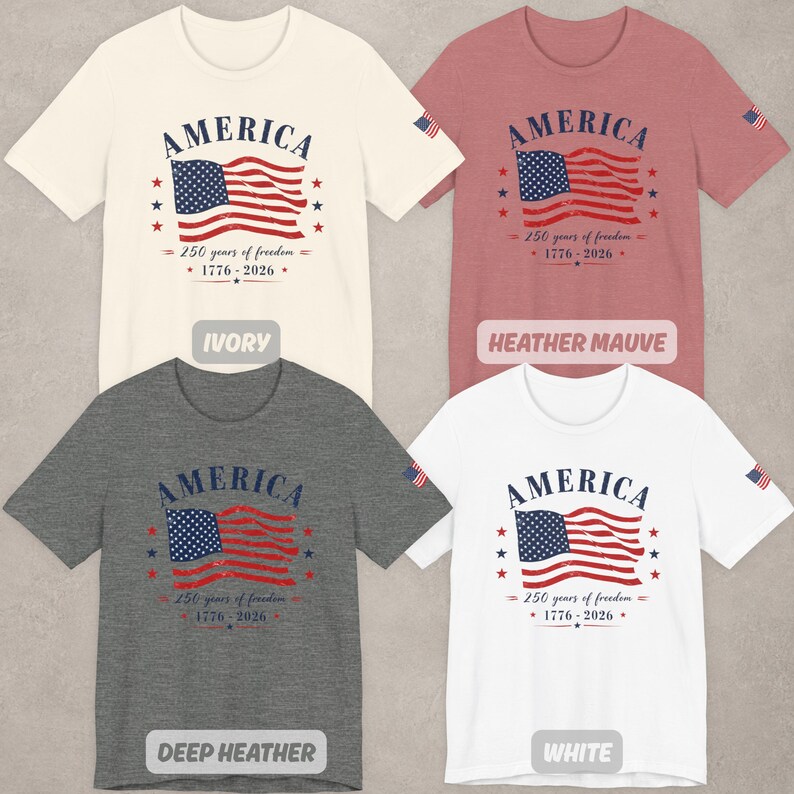 May include: Four short-sleeve t-shirts in ivory, heather mauve, deep heather, and white. Each shirt features a graphic of an American flag with the text AMERICA, 250 years of freedom, and 1776-2026. A small American flag is printed on the left sleeve.