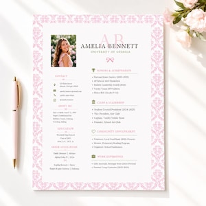 May include: A resume template featuring a pink damask border, a photograph of a person, and the name Amelia Bennett. The document includes sections for contact, education, honors, clubs, community involvement, and work experience with a pink pen.