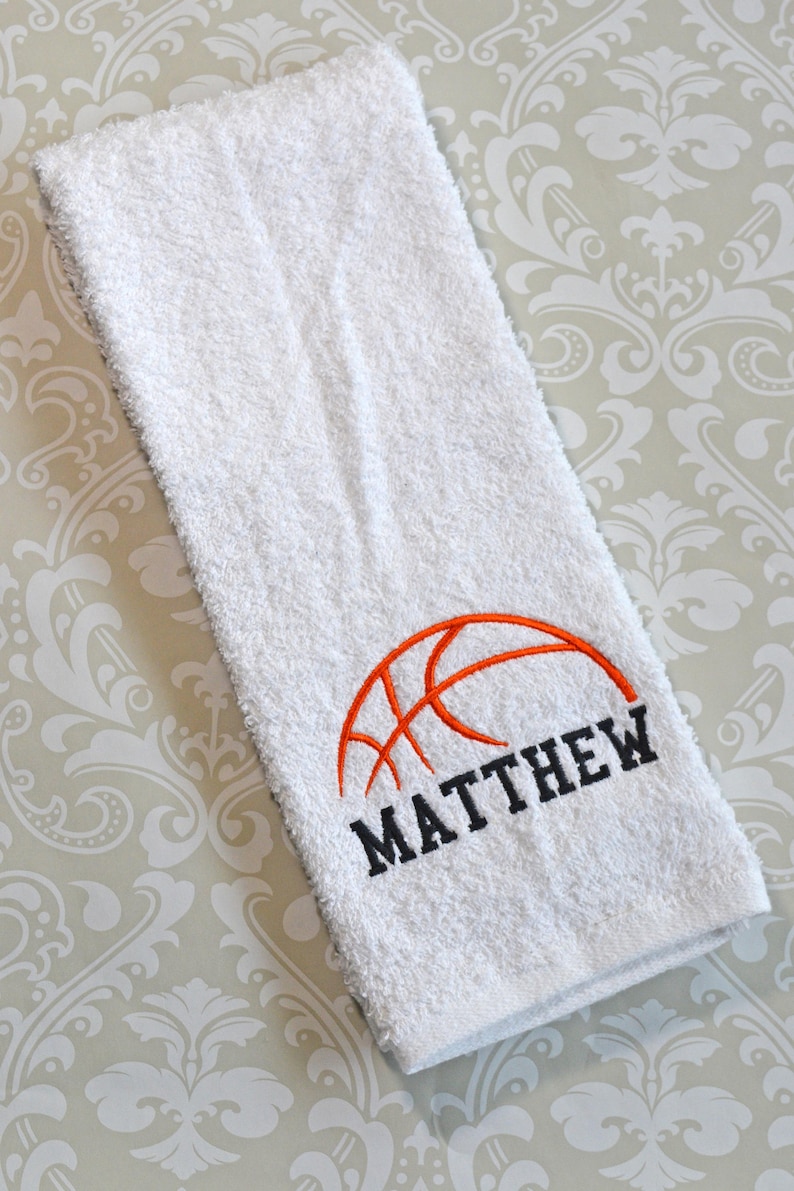 May include: White towel with an orange basketball and the name "MATTHEW" embroidered in black.