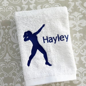 May include: White towel with a blue silhouette of a person doing the dab dance and the name "Hayley" embroidered in blue thread.