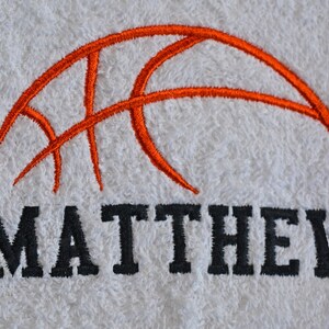 May include: White towel with an orange embroidered basketball and the name "MATTHEW" in black embroidery.