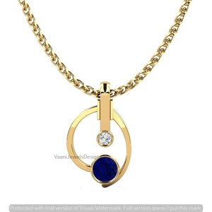 May include: A gold necklace featuring a pendant with a circular frame, a vertical bar, a small clear round gemstone, and a larger round deep blue gemstone. The pendant hangs from a gold chain. The text VaaniJewelsDesign is visible on the pendant.