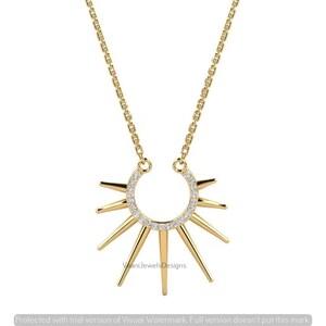 May include: A gold necklace featuring a sunburst pendant with a semi-circular top section encrusted with small clear stones. The pendant has radiating pointed rays extending downward from the base. The chain is a delicate gold link style.
