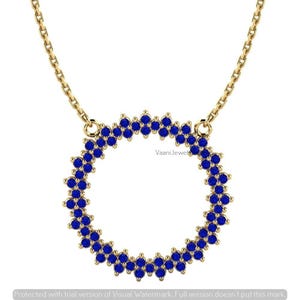 May include: A gold chain necklace featuring a circular pendant composed of numerous small, round, vibrant blue gemstones arranged in a double-row pattern. The pendant is attached to the chain at two points, creating a balanced, symmetrical design.