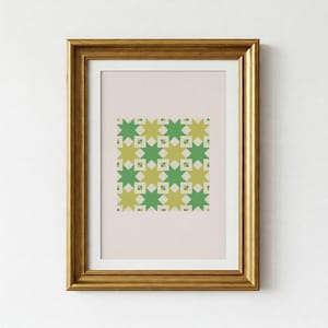 May include: A framed print featuring a geometric pattern of green and light green star shapes and small diamonds on a light pink background. The artwork is encased in a gold-colored wooden frame, suitable for wall decor.