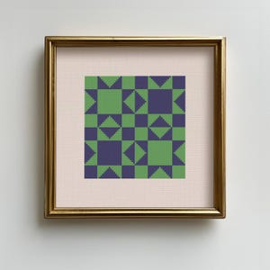 Puede incluir: Una obra de arte en punto de cruz enmarcada con un patrón geométrico de cuadrados, triángulos y diamantes verdes y morados. La obra está sobre un fondo rosa claro y enmarcada en un marco dorado.