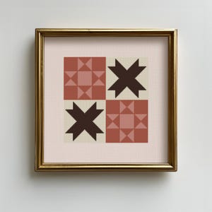 May include: Framed artwork featuring a geometric quilt pattern. The design includes four squares with alternating star and square patterns in shades of brown, beige, and pink. The artwork is encased in a gold-colored frame, adding a touch of elegance.