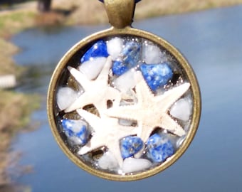 May include: A bronze pendant necklace with a round glass charm filled with white and blue stones and three white starfish.