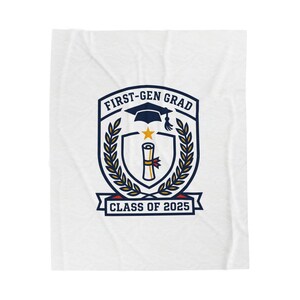 May include: White blanket with a navy blue and gold graduation emblem. The emblem features the text "FIRST-GEN GRAD" above a graduation cap, a diploma, and the text "CLASS OF 2025". The design is framed by a laurel wreath.