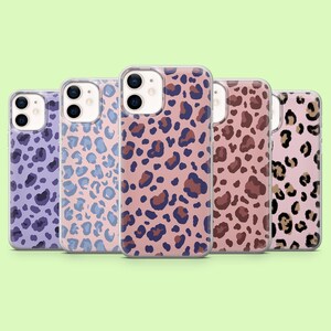 May include: Five phone cases with leopard print designs in various colors, including purple, blue, pink, and brown. The cases are arranged in a row against a light green background. The leopard spots vary in size and color.