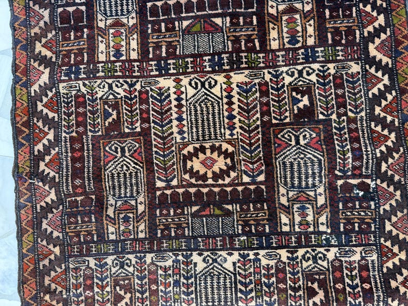 May include: A woven rug featuring a complex geometric pattern with a dark brown background. The design includes repeating architectural motifs, stylized floral elements, and vertical columns in shades of cream, red, blue, and green.