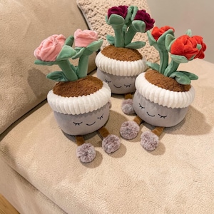 Może przedstawiać: Zestaw trzech ceramicznych kubków z nakrapianym, matowym wykończeniem. Kubki są w odcieniach kremu, jasnoszarym i ciemnoszarym. Każdy kubek ma prosty, nowoczesny design i zaokrąglony uchwyt.