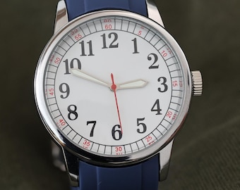 May include: A silver-cased wristwatch with a white face and black numerals. The watch has a red second hand and a blue silicone band. The watch is set against a dark green background.
