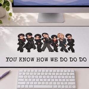 May include: A rectangular white desk mat featuring a black border and a central graphic of seven chibi-style figures dressed in dark formal attire. Below the figures, the text reads YOU KNOW HOW WE DO DO DO in a bold, black, typewriter-style font.