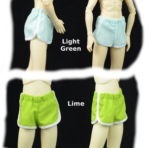 May include: Two pairs of athletic shorts with white piping. The shorts on the top are light green and the shorts on the bottom are lime green.