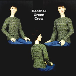 May include: A heather green crew neck sweater. The sweater is a knit fabric with a textured pattern. The sweater is shown on a model wearing blue jeans.