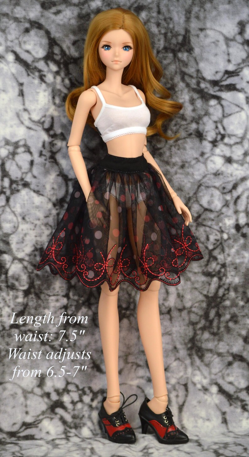 May include: A black tulle skirt with red embroidery and white polka dots. The skirt is 7.5 inches long and the waist adjusts from 6.5 to 7 inches.