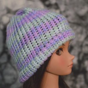 May include: A knitted hat in shades of purple, blue, and green. The hat has a ribbed texture and a slouchy fit.