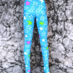 May include: Blue leggings with white, pink, and green stars. The leggings have a stretchy fabric and are perfect for everyday wear. "Stars on Blue" is written at the bottom of the image.