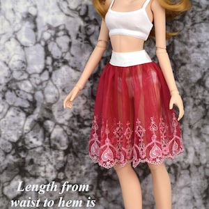 May include: A red tulle skirt with white lace trim and pink floral embroidery. The skirt is 7 inches long and the waist adjusts from 6 to 7 inches.