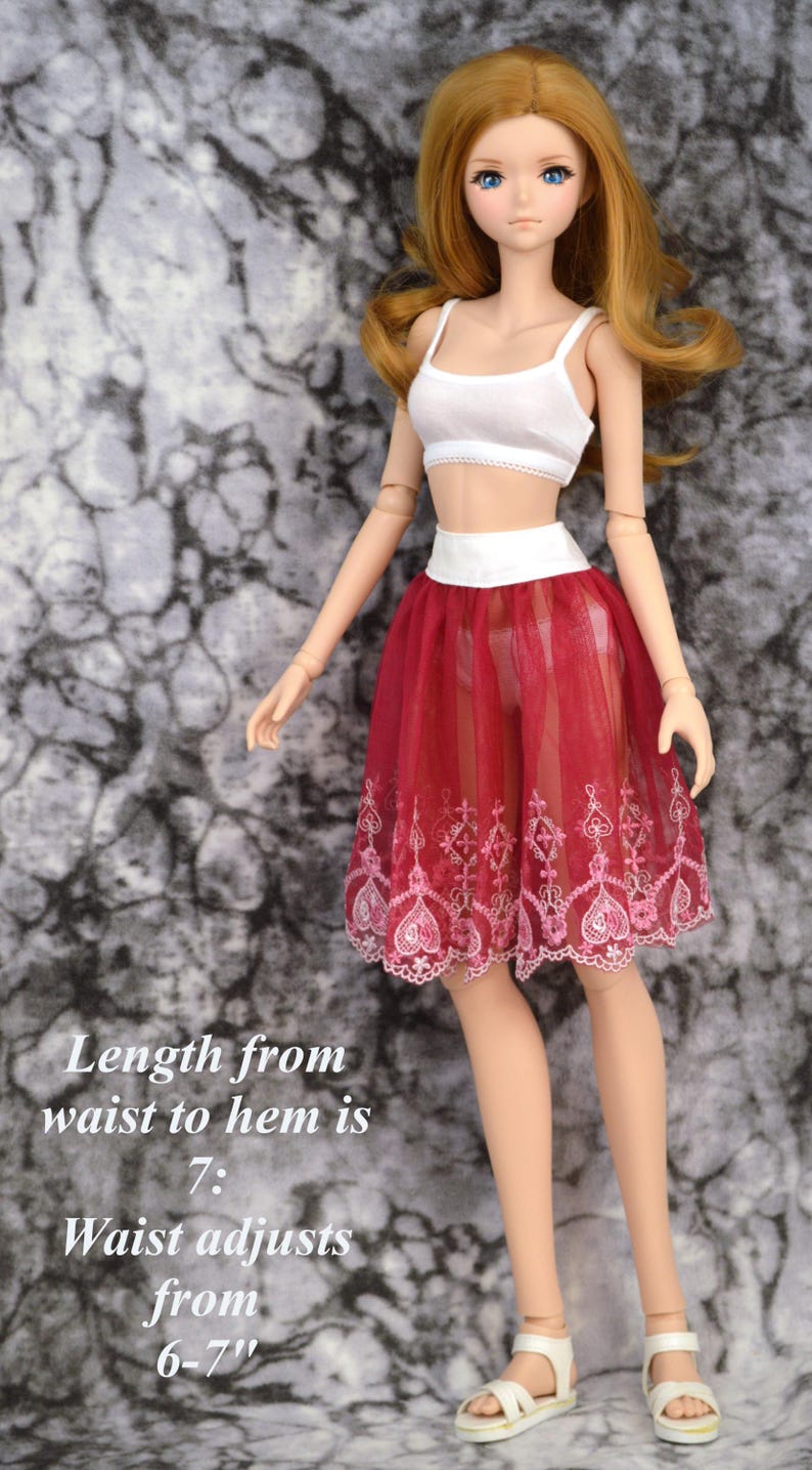 May include: A red tulle skirt with white lace trim and pink floral embroidery. The skirt is 7 inches long and the waist adjusts from 6 to 7 inches.