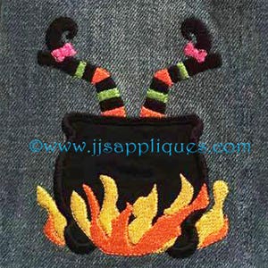 May include: Embroidered design of a witch's legs sticking out of a black cauldron with flames underneath. The cauldron is on a denim background. The text "www.jjsappliques.com" is visible below the cauldron.