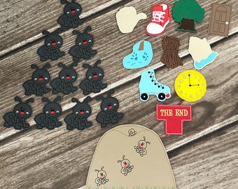Puede incluir: Un conjunto de apliques de fieltro para una historia infantil sobre hormigas. El conjunto incluye 12 hormigas negras, un hormiguero marrón, un zapato rojo, un patín azul, un árbol verde, una puerta marrón, un palo marrón, un reloj amarillo, una mano blanca y un cartel rojo que dice "THE END".