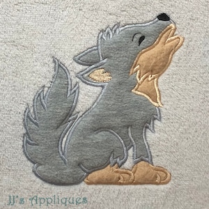 May include: A gray and brown embroidered applique of a wolf howling with its mouth open. The wolf is sitting on its haunches with its tail curled around its legs.