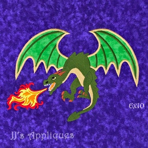 May include: Green dragon applique with gold trim, breathing fire, on a purple background. The applique is 6 inches by 10 inches.  JJ's Appliques.